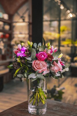 vase with flower composition on wooden table mix roses